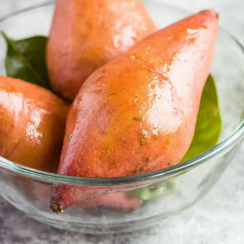 Raw sweet potatoes coated in oil in a glass bowl, ready for air frying