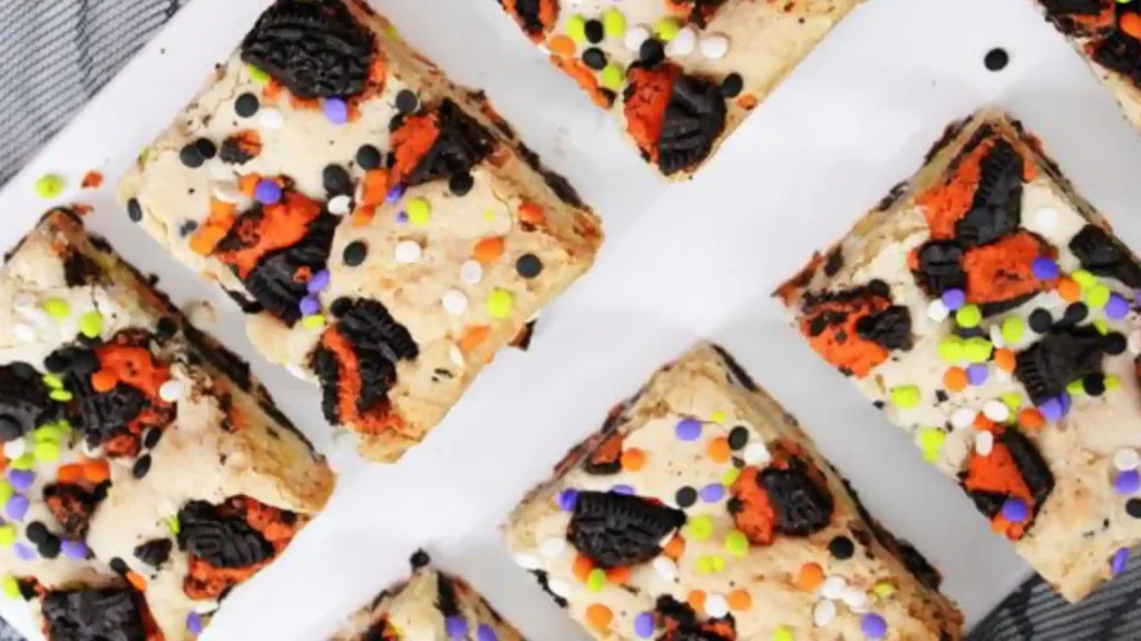 Top view of Halloween Oreo Cake Bars with colorful sprinkles and crushed Oreos on a white serving platter.