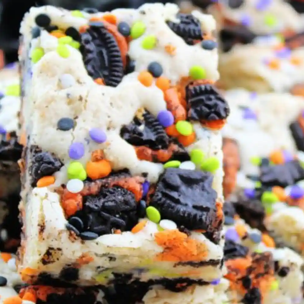 Close-up of a stacked Halloween Oreo Cake Bar topped with crushed cookies and colorful Halloween sprinkles.