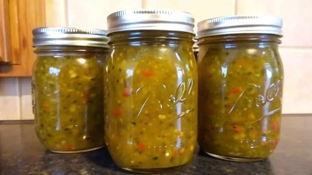 Three mason jars filled with homemade zucchini relish on a kitchen counter