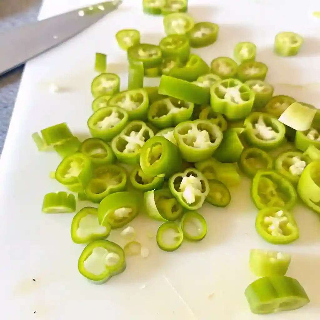 Sliced banana pepper rings on a white cutting board