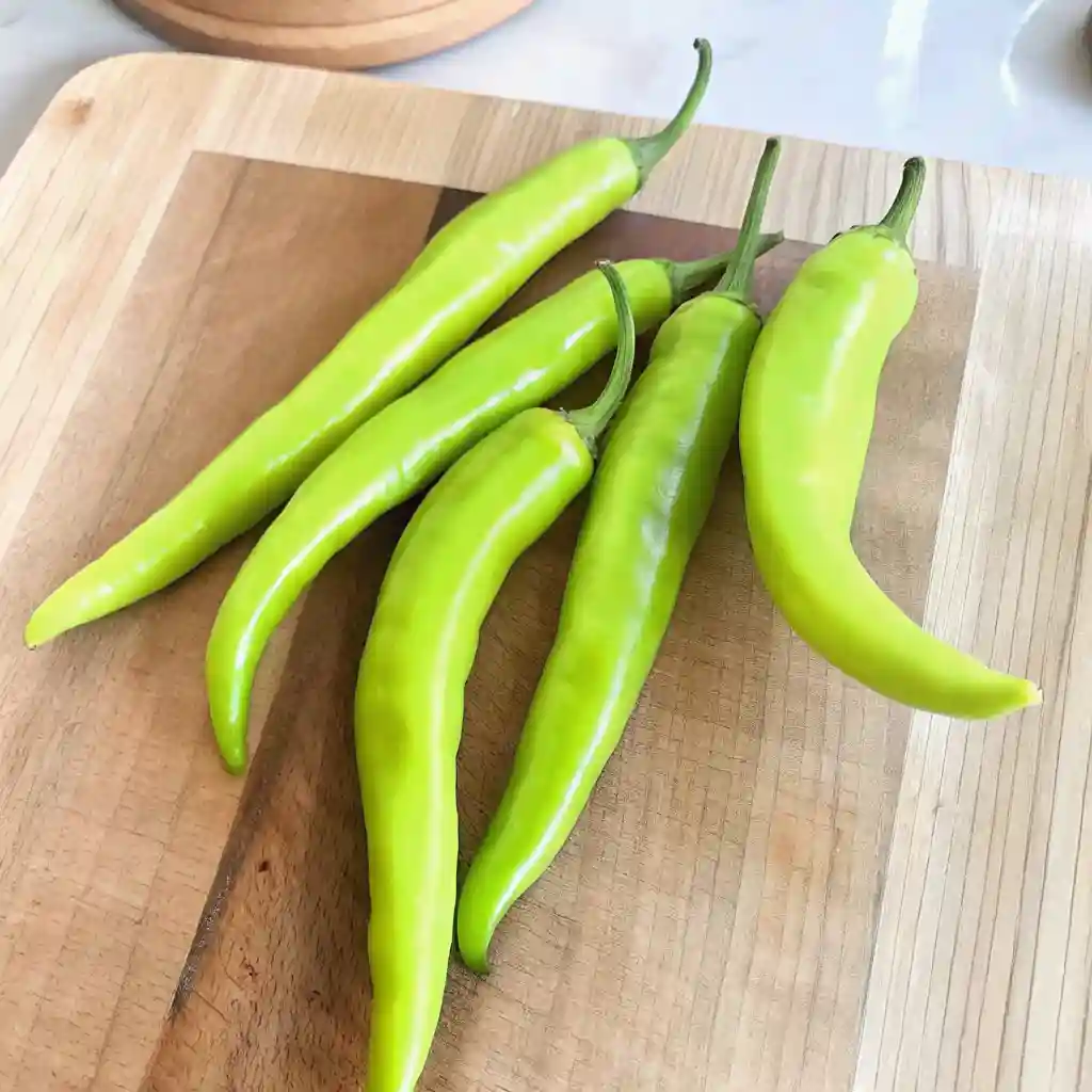 Fresh banana peppers on a wooden cutting board