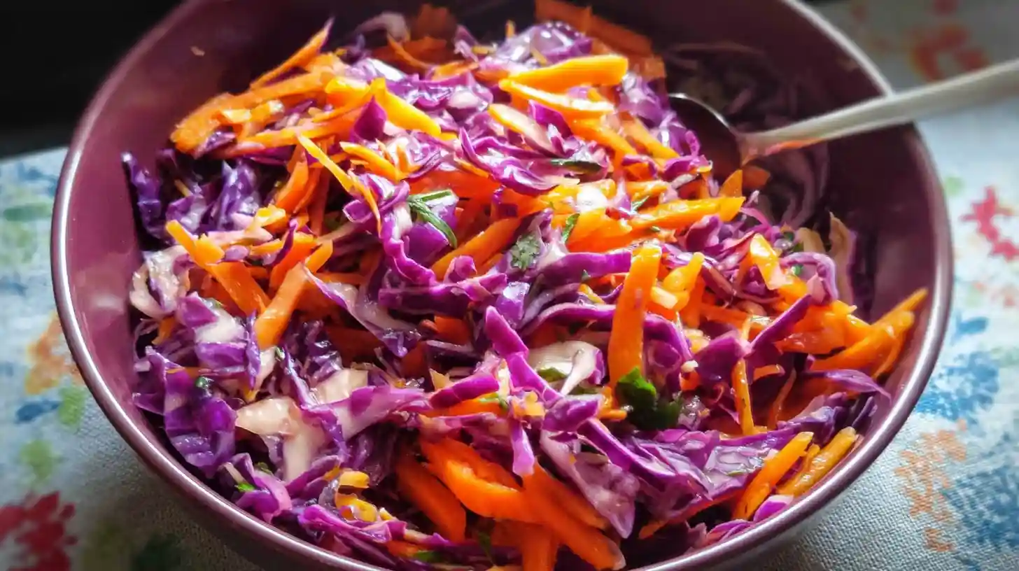 Close-up of red cabbage and carrot coleslaw with sesame seeds and herbs