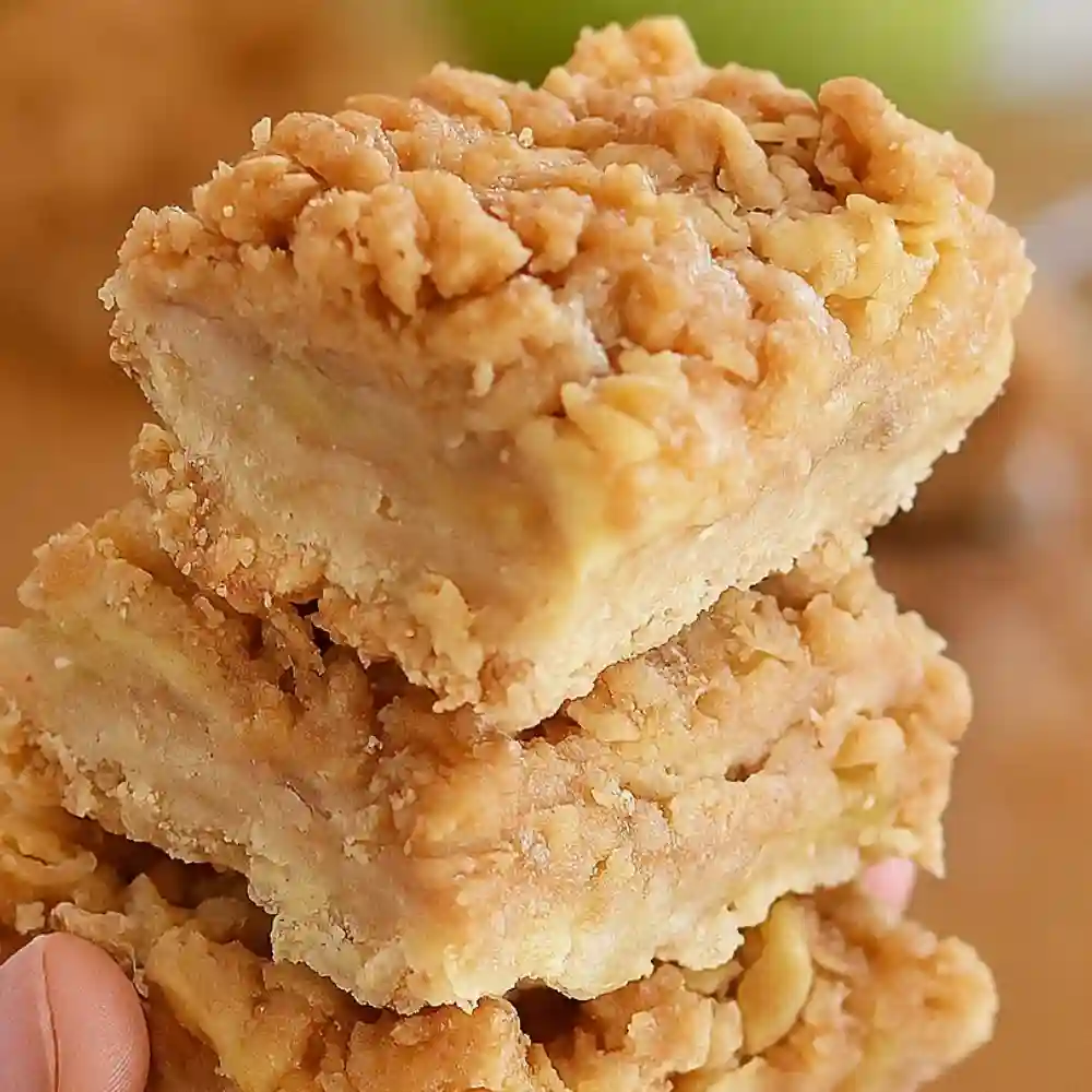 Stacked apple crisp bars with oat streusel topping and layered cinnamon apple filling