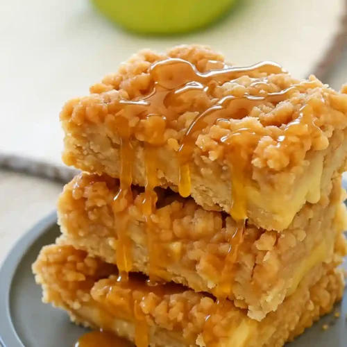 Apple crisp bars stacked with golden streusel topping and caramel drizzle