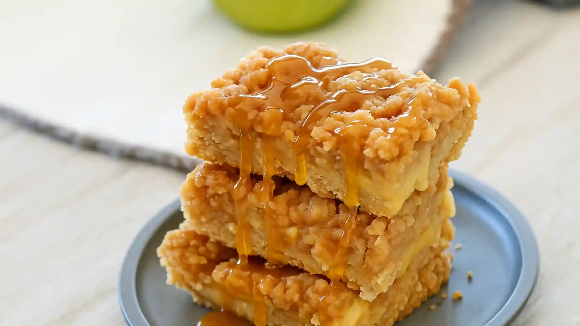 Apple crisp bars stacked with golden streusel topping and caramel drizzle