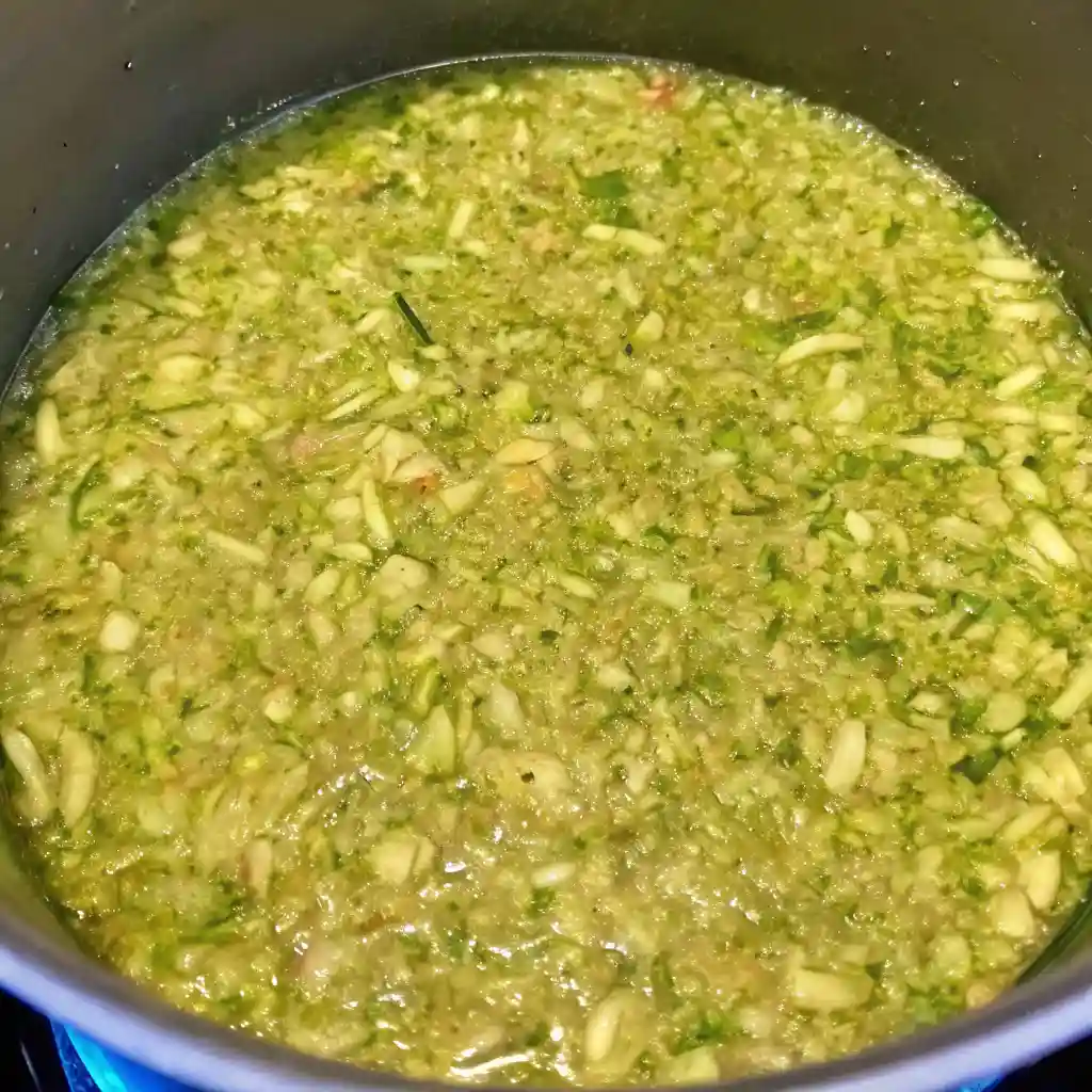 Sweet pickle relish simmering in a pot with chopped cucumbers, onions, and spices