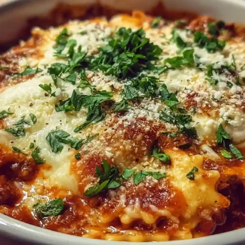 One-pot lasagna soup with melted cheese, fresh herbs, and rich tomato sauce served in a white bowl