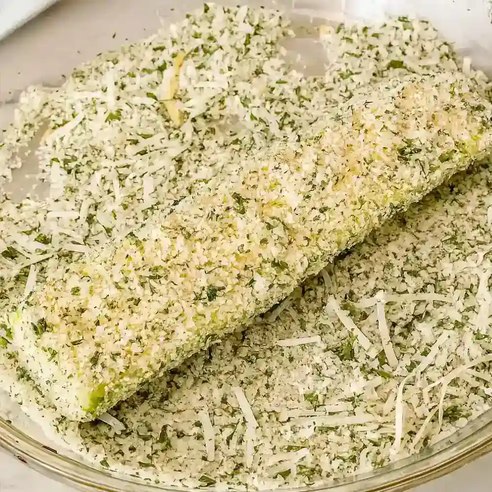 Zucchini slice coated in seasoned panko and Parmesan, ready to be baked for Three Cheese Zucchini Parmesan