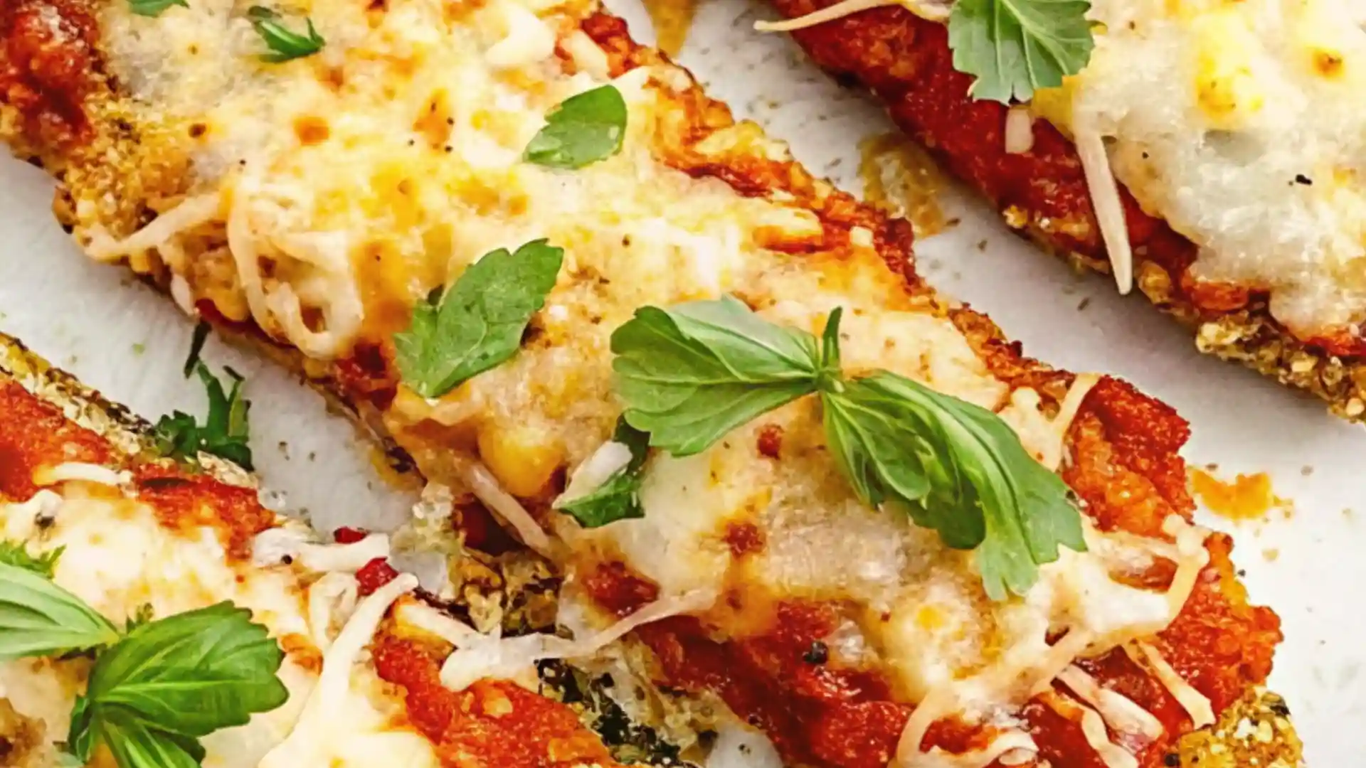 Crispy baked zucchini slices topped with marinara, melted three-cheese blend, and fresh herbs