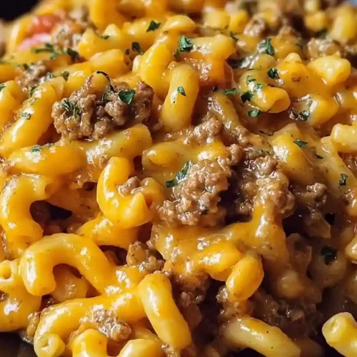 Close-up of creamy homemade hamburger helper with ground beef and cheddar cheese in a black bowl